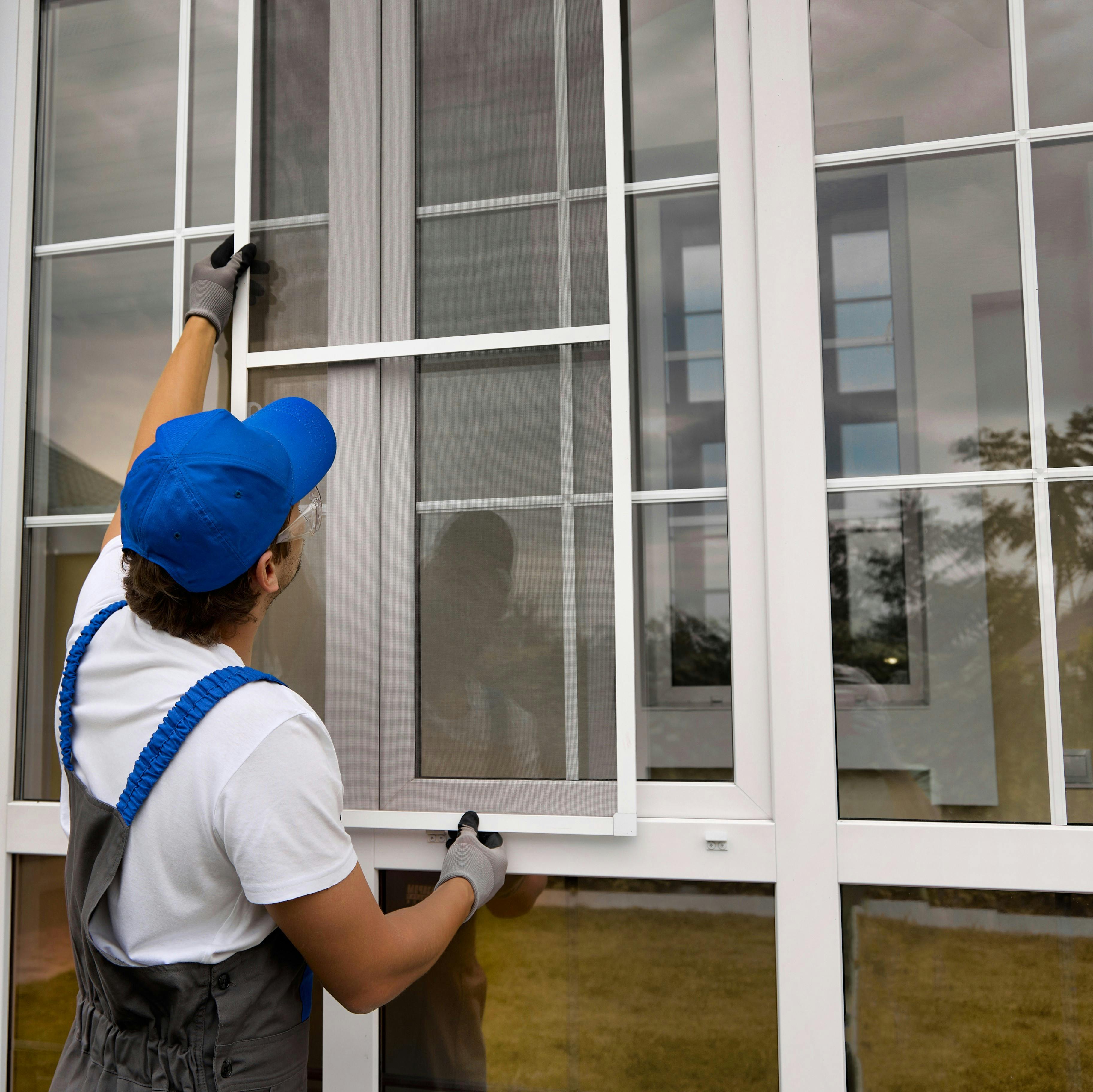 A person cleaning large, open windows