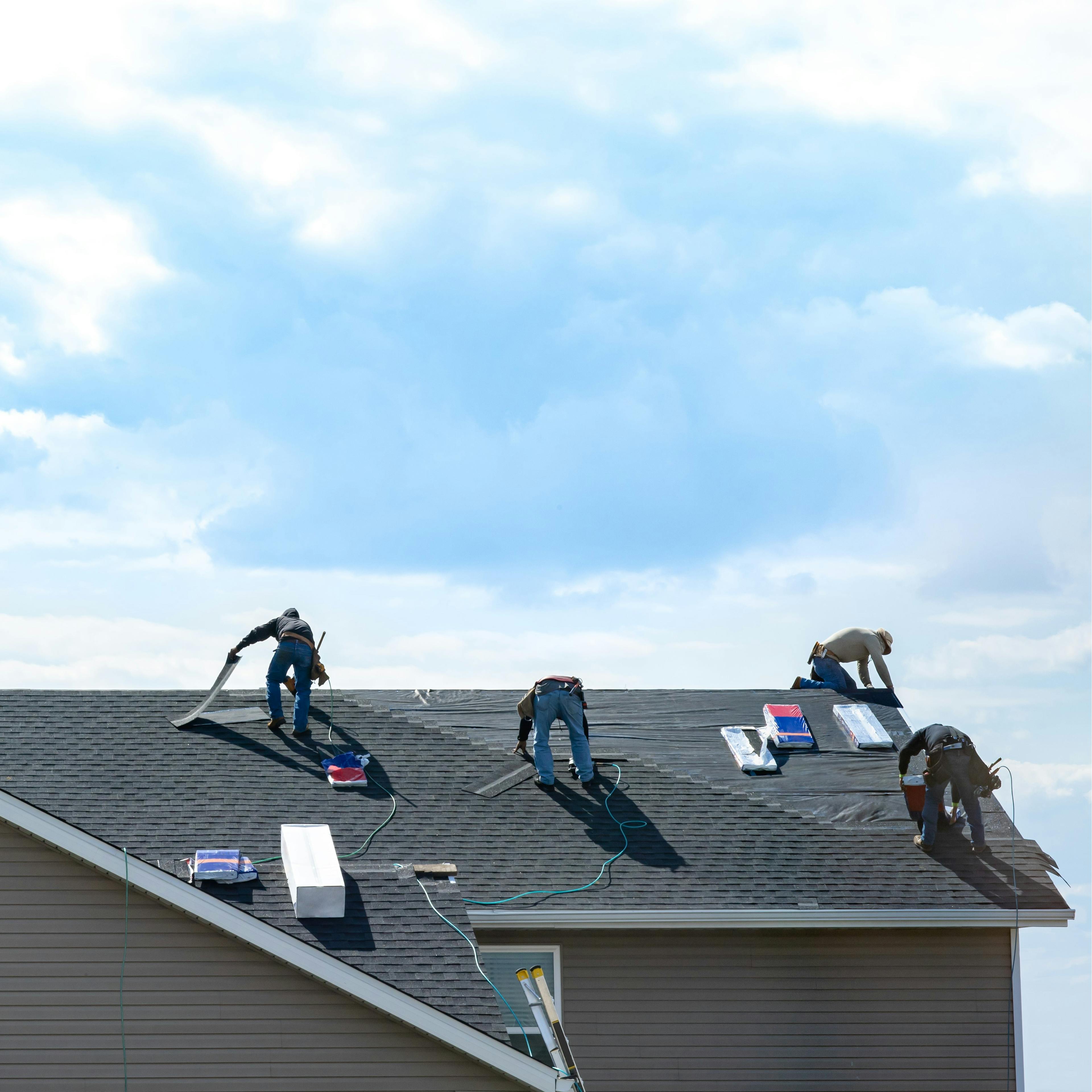 A roofing crew is hard at work installing a new asphalt shingle roof